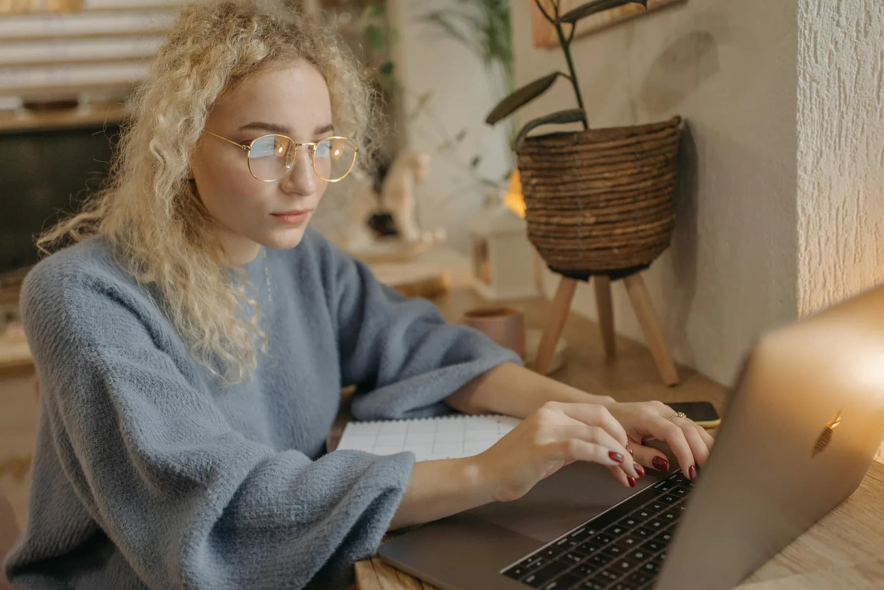 Person med laptop og papirer på hjemmekontoret